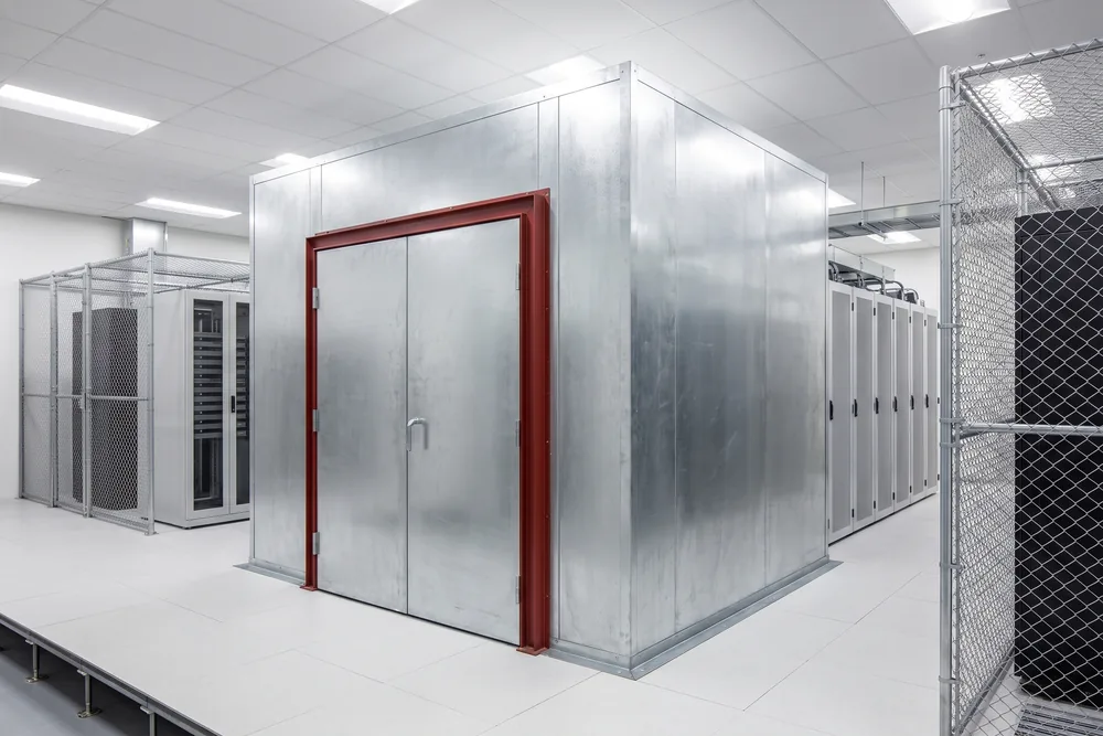 Modular shielded vault with a double-leaf RF door standing in a colocation hall