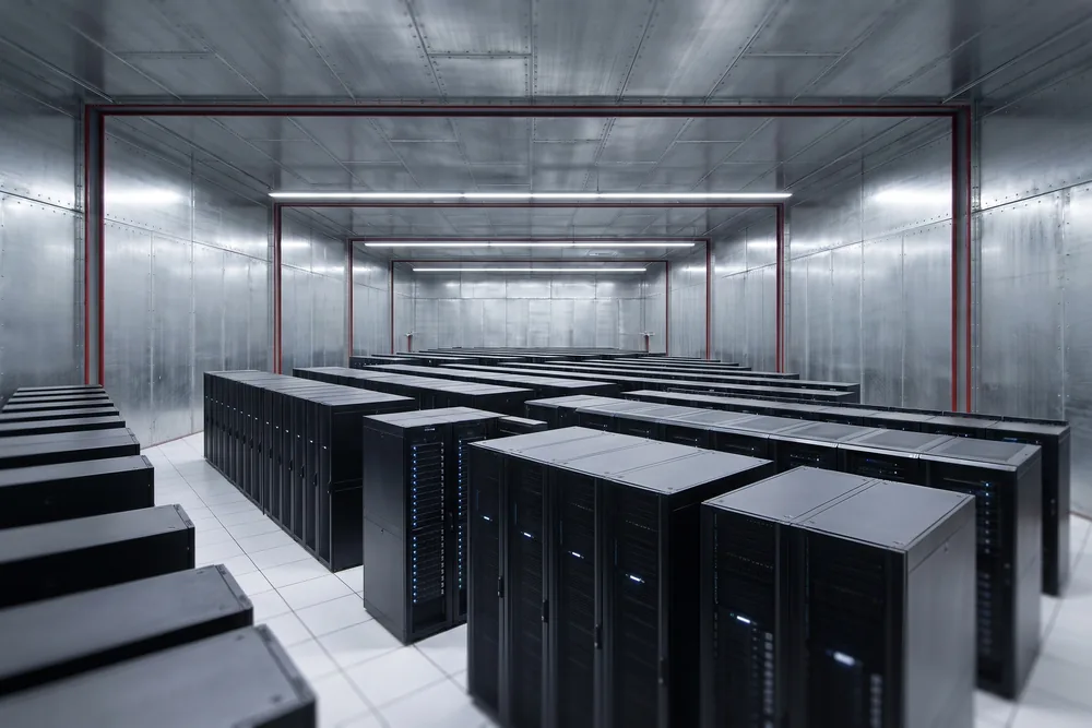 Rows of GPU racks inside a galvanized steel shielded hall with red frame accents