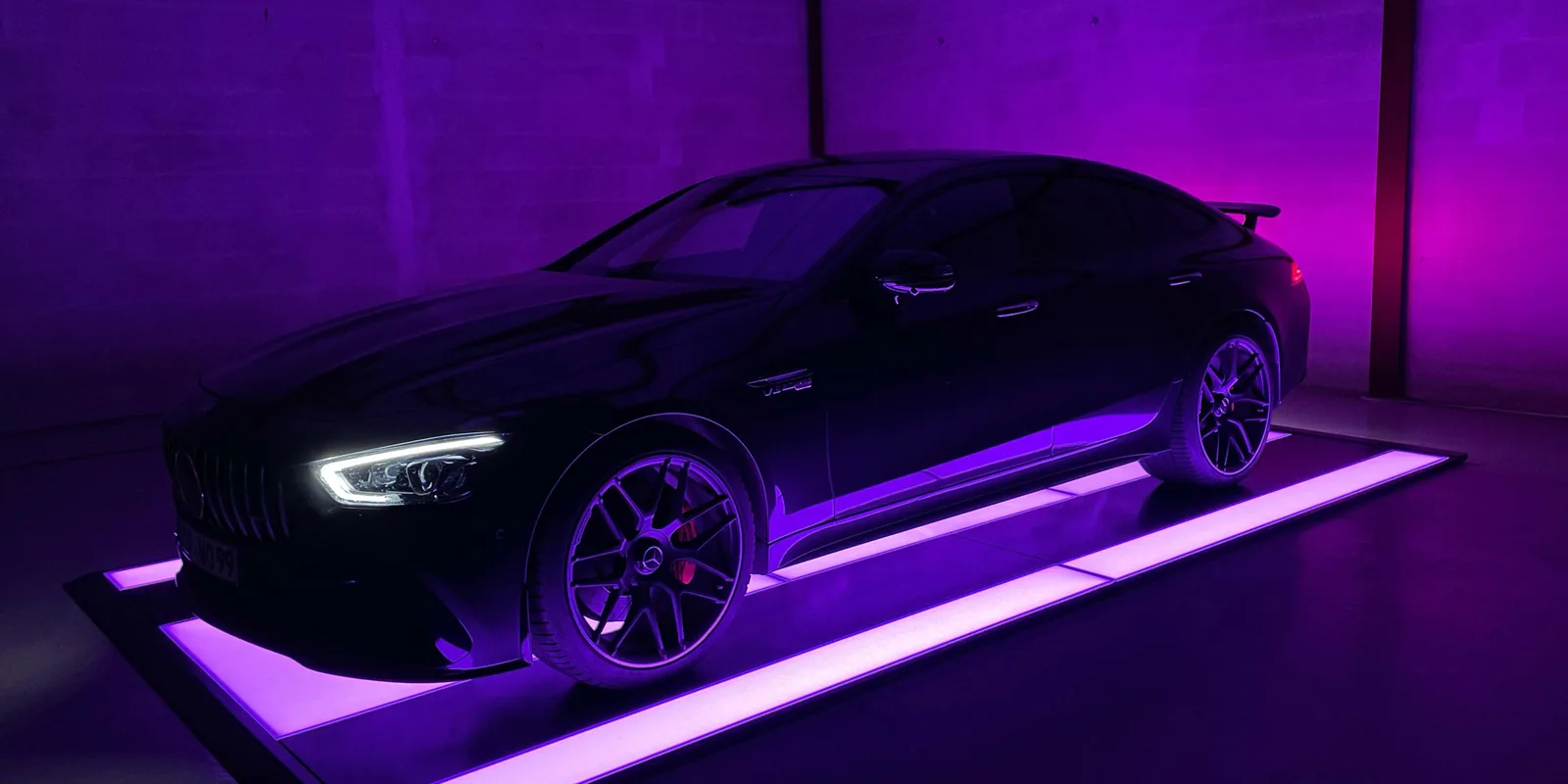 A performance saloon on a CarThrone lit violet and green
