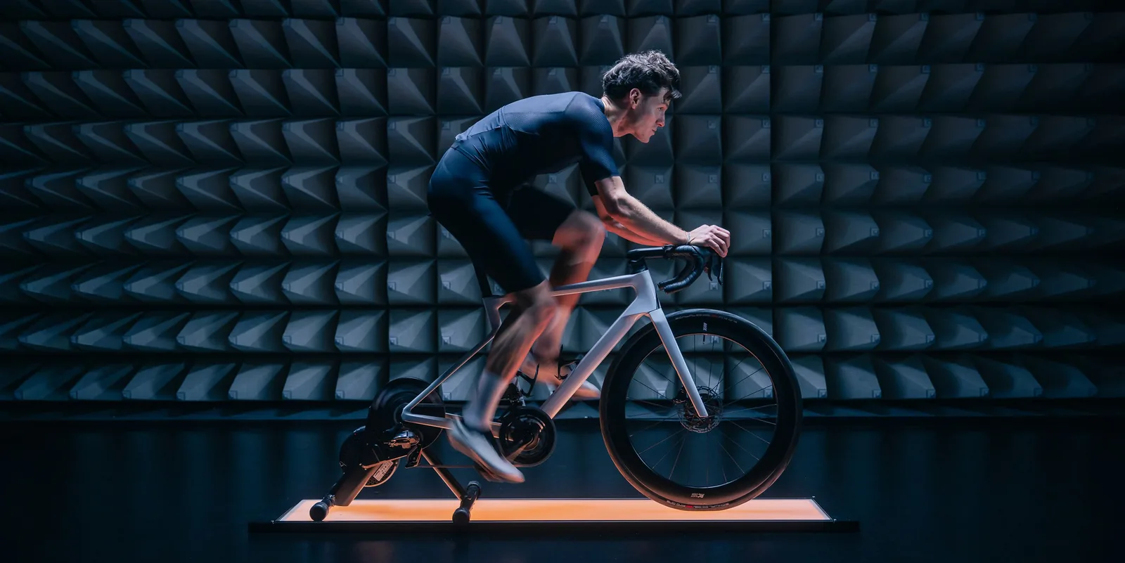 A cyclist on a road bike over a VeloThrone in a wind tunnel